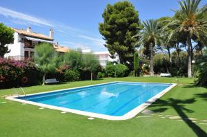 a swimming pool in the yard of a house at Apartamentos Sunway Talaia in Sitges