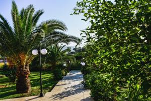 a walkway through a garden with palm trees at Villa Sweven, Luxury Living Chania in Souda