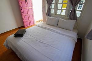 a bedroom with a white bed with a black briefcase on it at Vagary Pangkor in Pangkor +12 photos
