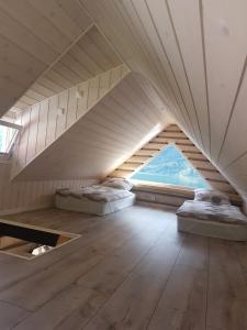 a attic room with two beds and a window at Bazyl Apartment in Folkedal