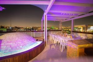 ein Restaurant mit einem langen Tisch auf einem Balkon in der Nacht in der Unterkunft Western Wall Luxury House in Jerusalem
