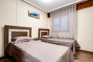 a bedroom with two beds and a window at Canonigo Torres in Torrevieja