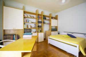 a bedroom with a bed and a desk and book shelves at Villa Pina in LʼAquila