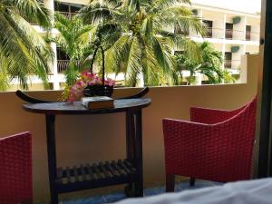 a table with two chairs and a table with flowers on it at NB House in Karon Beach