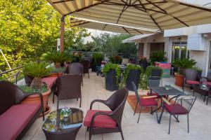 eine Terrasse mit Tischen und Stühlen unter einem Sonnenschirm in der Unterkunft Villa Mila in Tučepi