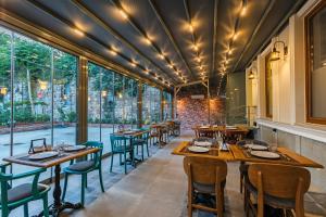 un restaurante con mesas y sillas de madera y ventanas grandes en Obelisk Hotel & Suites, en Estambul
