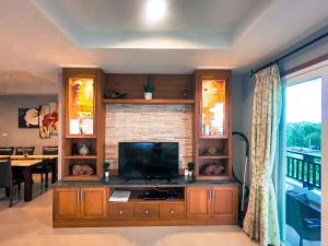 Khanom Sea Breeze apartment في خانوم: غرفة معيشة مع تلفزيون بشاشة مسطحة في مركز ترفيهي