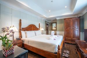 1 dormitorio con 1 cama grande y cabecero de madera en The Orchid House 153, en Bangkok