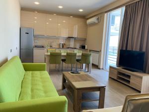 a living room with a green couch and a kitchen at Gonio Beachfront Panorama in Gonio