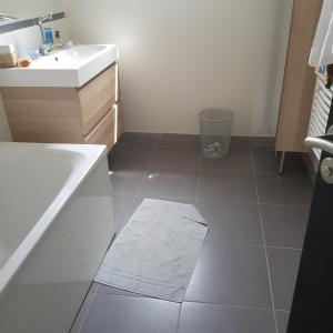ein Badezimmer mit einem Waschbecken und einer Badewanne sowie Fliesenboden in der Unterkunft Maison architecte in Romilly-sur-Andelle