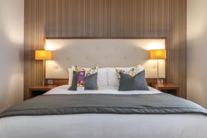 um quarto com uma cama grande e 2 candeeiros em Samlesbury Hotel em Preston