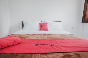 ein Bett mit einer rosa Decke darüber in der Unterkunft RedDoorz near Gatot Subroto Lampung 2 in Bandar Lampung
