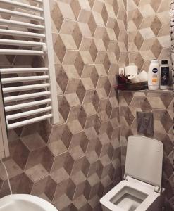 een badkamer met een toilet en een betegelde muur bij Laguna apartment in Tivat