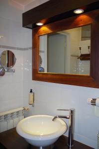 y baño con lavabo blanco y espejo. en Cit'Hotel des Messageries, en Saintes