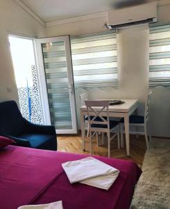 a room with a bed and a table and chairs at Laguna apartment in Tivat