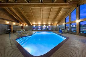 a large swimming pool in a building with windows at AmericInn by Wyndham Merrill in Merrill