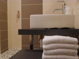 a bathroom with a sink and towels on a table at Cit'Hotel des Messageries in Saintes +52 photos