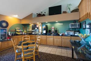 a kitchen with a counter and a table and chairs at AmericInn by Wyndham Merrill in Merrill