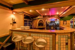 a restaurant with four stools at a bar at Hotel Nahar Nilgiris in Ooty