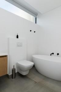 a bathroom with a white tub and a toilet at Central Beach Villas in Cape Town