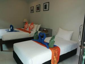 Sun Moon Star Resort Koh Phangan في هاد ياو: غرفة نوم بسريرين عليها شريط ازرق
