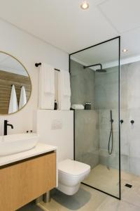 a bathroom with a toilet and a sink and a shower at Central Beach Villas in Cape Town