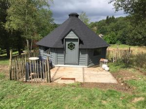 una pequeña casa de juegos con techo negro en La cabane de l'Atelier, en Bomal