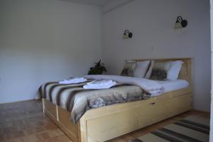 a bedroom with a wooden bed with towels on it at Casa Muskátli Vendégház in Sovata