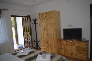 a bedroom with a bed and a tv and a dresser at Casa Muskátli Vendégház in Sovata