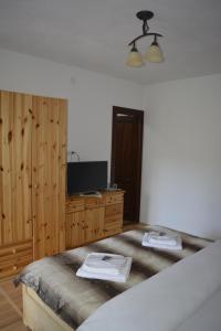 a bedroom with a bed and a dresser and a television at Casa Muskátli Vendégház in Sovata +16 photos