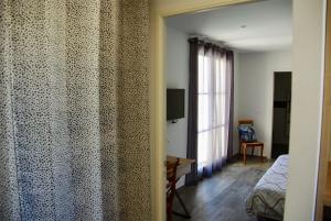 Cet appartement comprend une chambre avec un lit et une fenêtre. dans l'établissement UZES DECOUVERTES, à Uzès