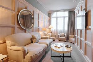 a living room with a couch and a mirror at The Scotsman Hotel in Edinburgh