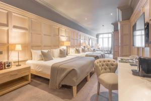 a hotel room with two beds and a television at The Scotsman Hotel in Edinburgh