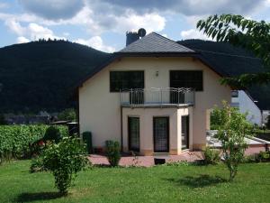 a white house with a balcony in a yard at Ferienappartement Lieser in Bernkastel-Kues