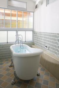a white bath tub in a bathroom with windows at Nanten-En in Kawachinagano