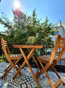 a wooden table and two chairs on a patio at Topolove Rooms & Apartments in Kraków