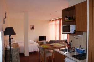 ein Zimmer mit einer Küche und ein Schlafzimmer mit einem Bett in der Unterkunft Résidence La Providence ZENAO Lisieux in Lisieux
