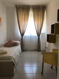 1 dormitorio con 1 cama y una ventana con cortinas en Le Miromí, en Civitanova Marche