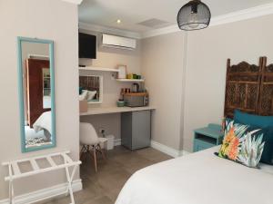Un dormitorio con una cama, un escritorio y un espejo. en NOOii Open Plan Room, en Pretoria