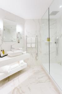 a white bathroom with a sink and a shower at The Scotsman Hotel in Edinburgh