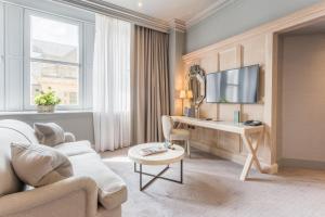 a living room with a desk and a tv at The Scotsman Hotel in Edinburgh