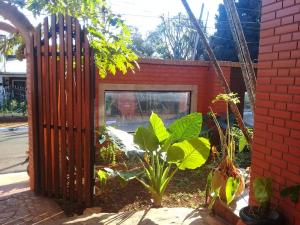 una recinzione di legno di fronte a un edificio con piante di El Uru Suite Hotel a Puerto Iguazú