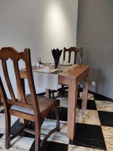drewniany stół z dwoma krzesłami i parasolem w obiekcie L'Escape Grill w mieście Silenrieux