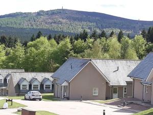 a row of houses with a mountain in the background at Inchmarlo Golf Resort, Banchory Villa 38 AS00482F in Inchmarlo