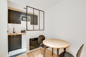 - une cuisine avec une table et des chaises en bois dans l'établissement Pick A Flat's Apartment in Bastille - Rue du Chemin Vert, à Paris