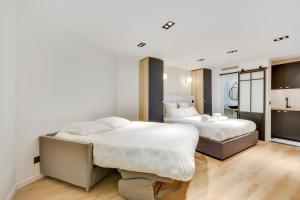 a bedroom with two beds and a kitchen at Pick A Flat's Apartment in Bastille - Rue du Chemin Vert in Paris