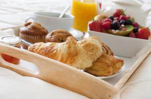 a breakfast tray with pastries and a bowl of fruit at Belmont House Boutique - the Kingsley collection in Berwick-Upon-Tweed +37 photos