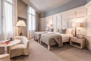 a hotel room with two beds and a chair at The Scotsman Hotel in Edinburgh