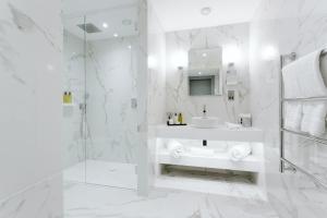 Baño blanco con lavabo y espejo en The Scotsman Hotel, en Edimburgo