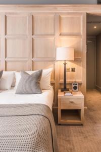 a bedroom with two beds and a table with a lamp at The Scotsman Hotel in Edinburgh